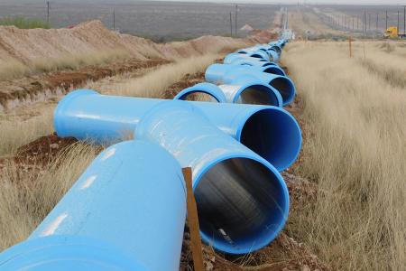 Large diameter blue pipe in field